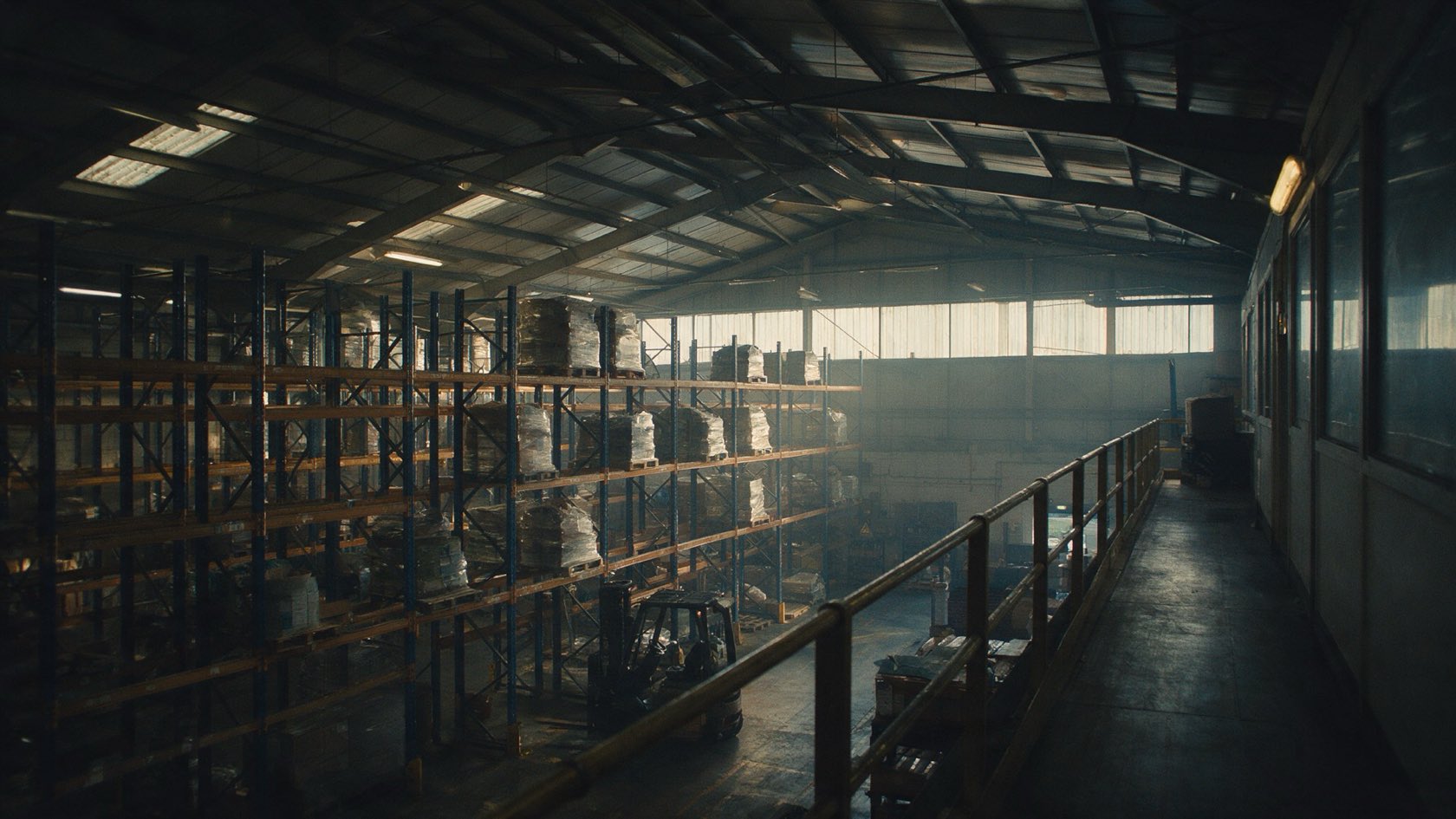 A distribution warehouse at the end of a shift, racking receding into depth