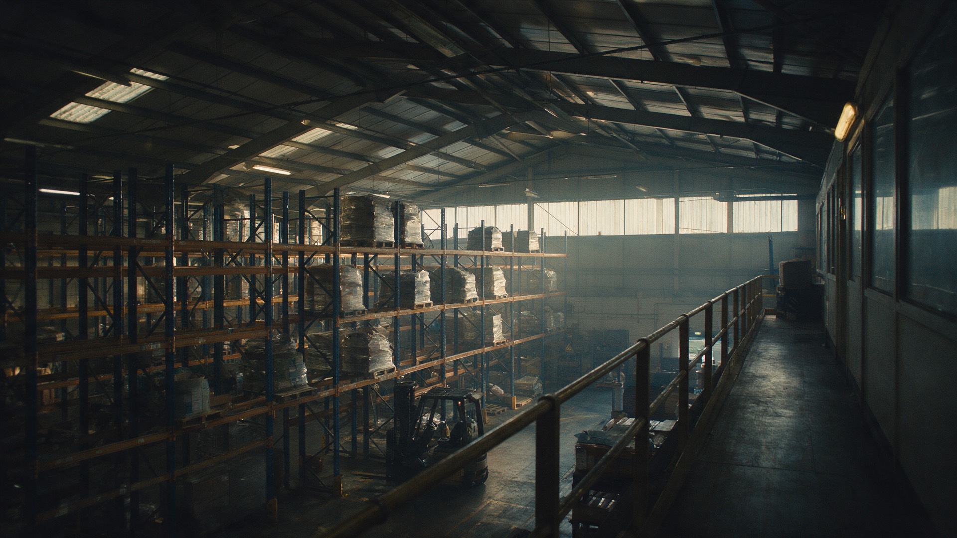 A distribution warehouse at the end of a shift, racking receding into depth